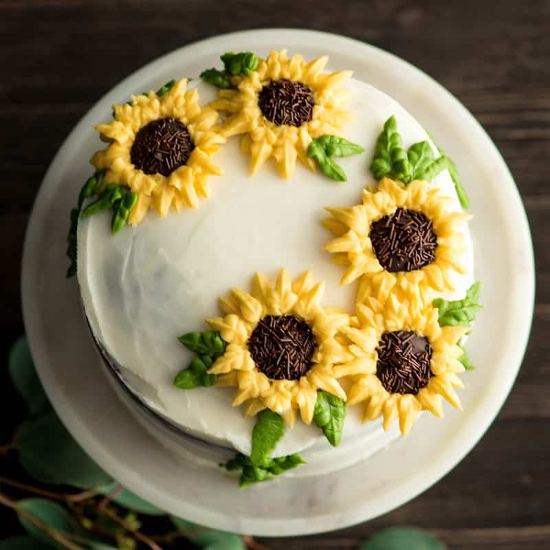 overhead view of a sunflower cake decorated with the best homemade vanilla frosting recipe