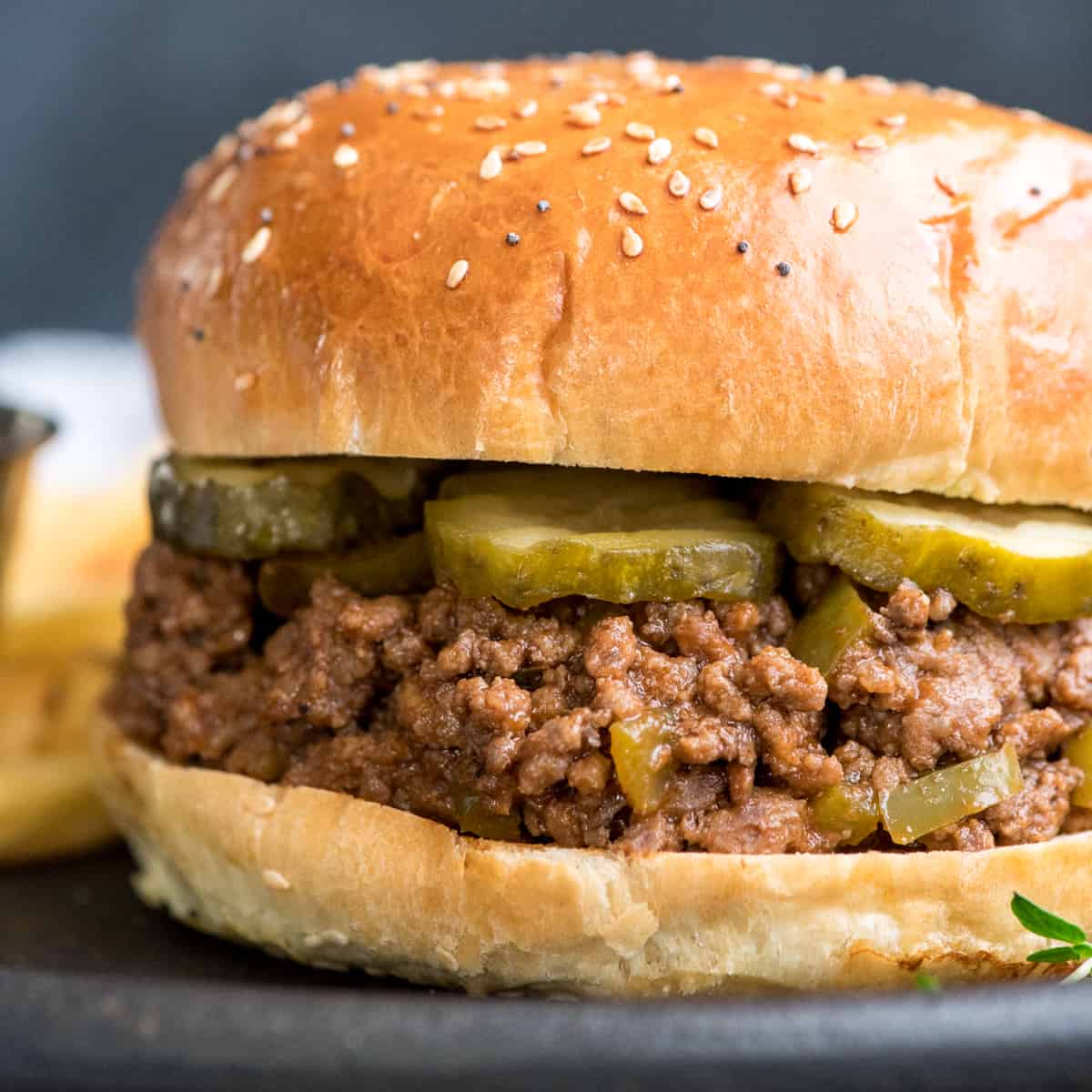 Up close front shot of healthy sloppy joes recipe on a bun with pickles 