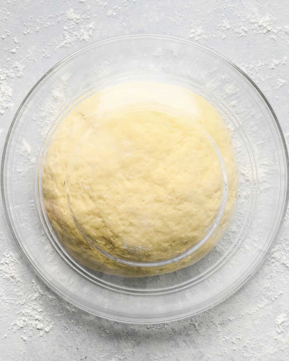 potato gnocchi dough covered by a glass bowl on a floured surface