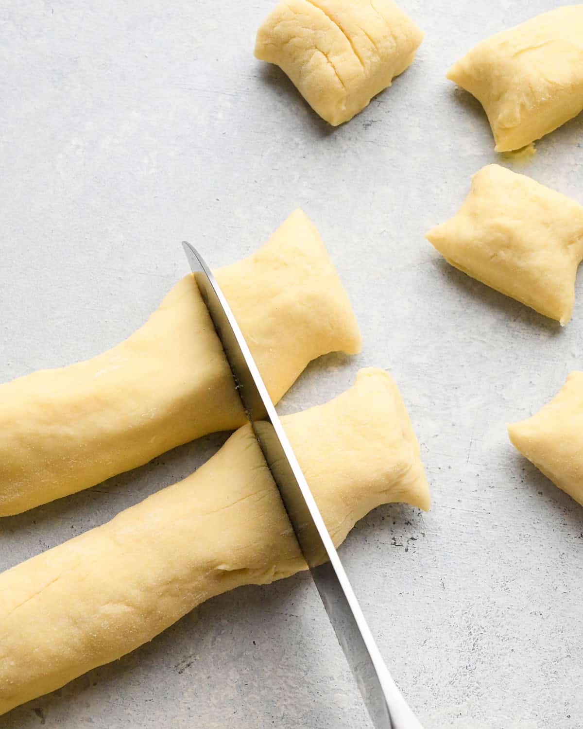 How to Make Potato Gnocchi - cutting pieces of gnocchi from the dough ropes