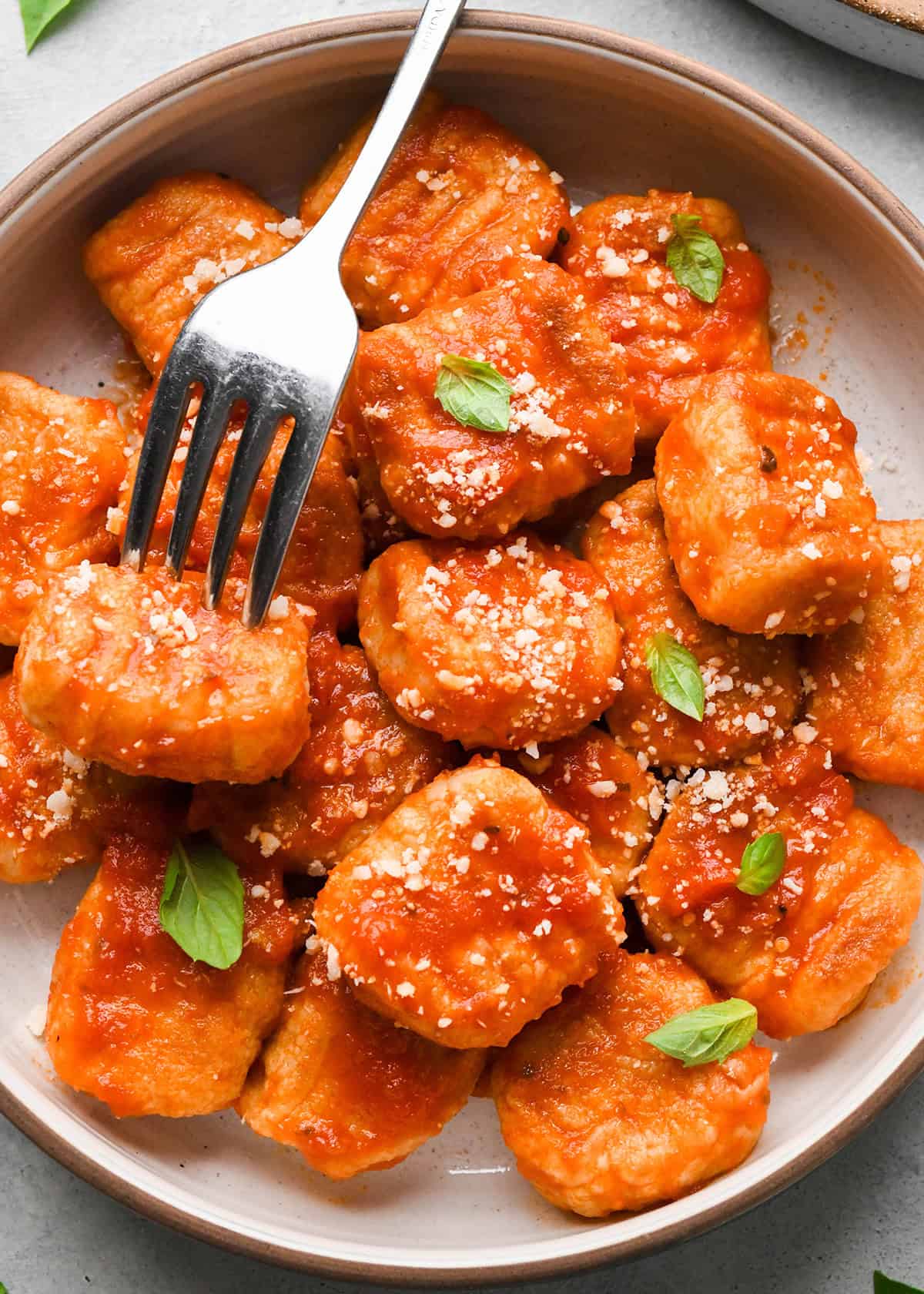 Potato Gnocchi in a bowl with marinara sauce and ad fork