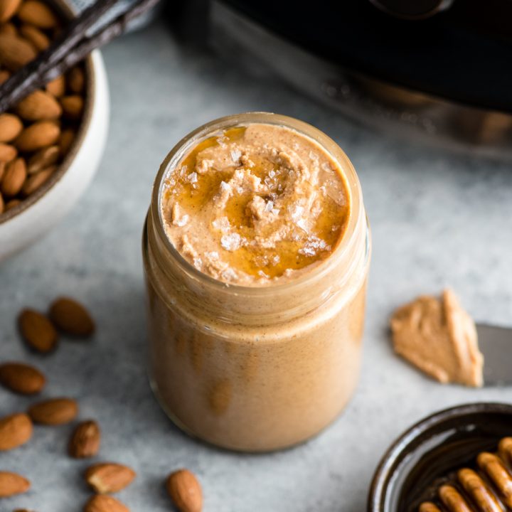 glass jar of vanilla almond butter topped with honey and sea salt 