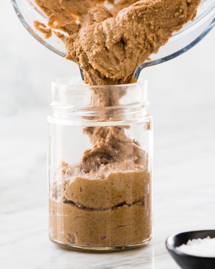 Vanilla Almond Butter being poured into a glass jar 