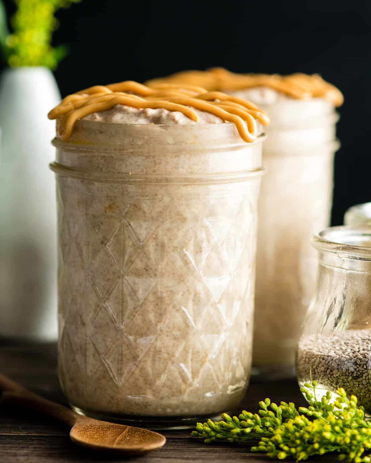 Front view of two jars of Peanut Butter Chia Overnight Oats with peanut butter drizzle