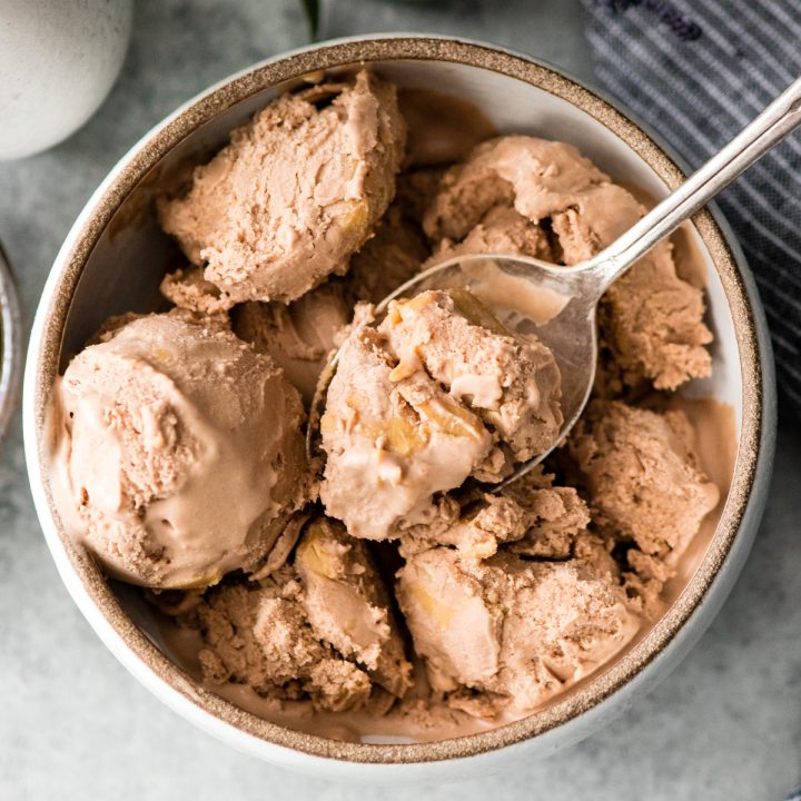 Overhead view of a spoon with a big bite of Dairy-Free Chocolate Peanut Butter Ice Cream on it resting on top of a bowl of Dairy-Free Chocolate Peanut Butter Ice Cream 