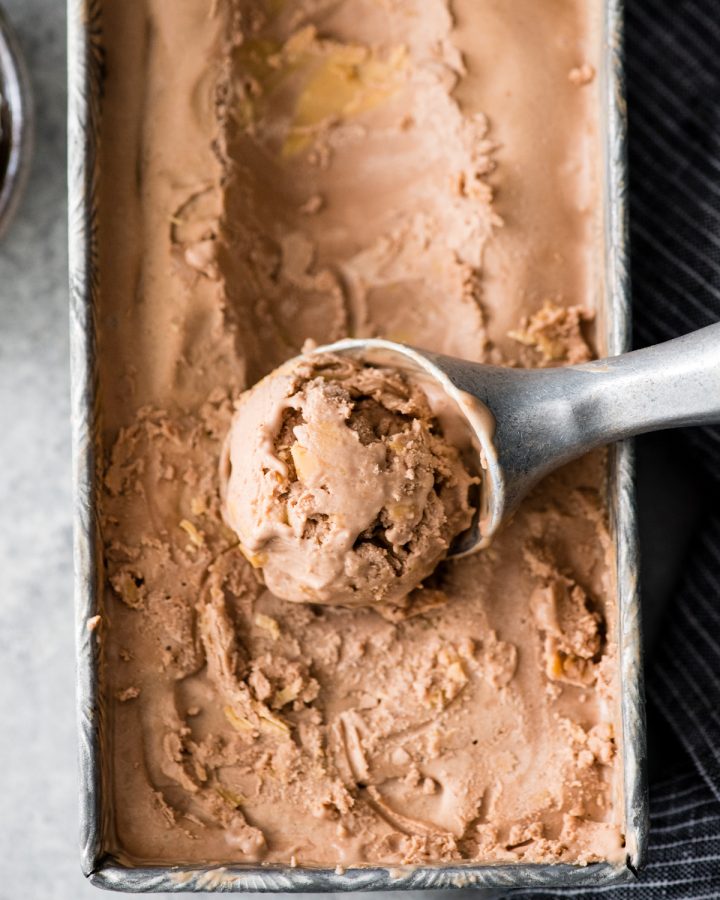 overhead view of dairy-free chocolate peanut butter ice cream being scooped out of a container