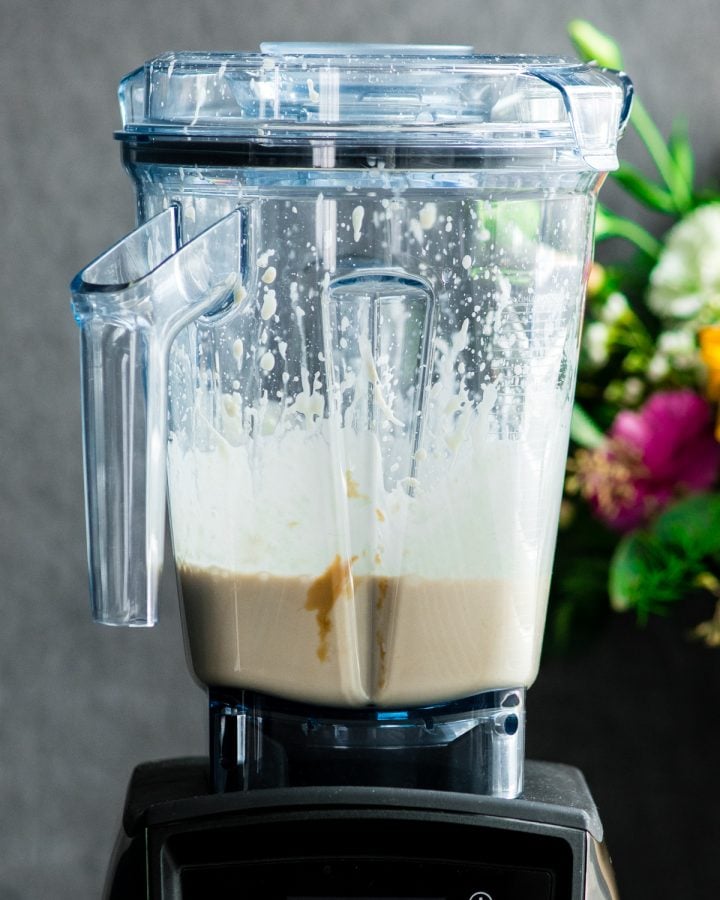 Front view of a Vitamix blender with the finished Paleo Vanilla Ice Cream mixture inside