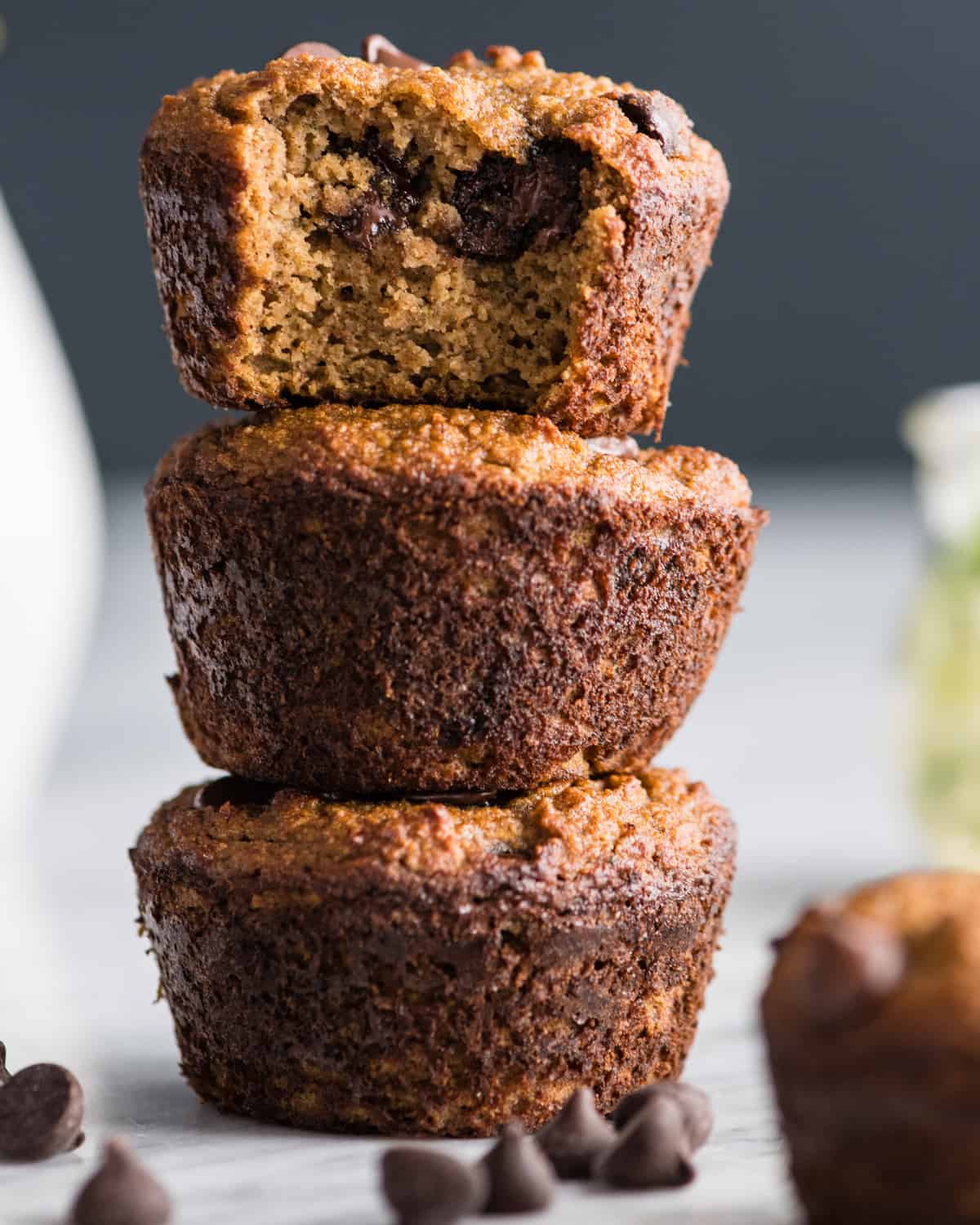 stack of 3 paleo zucchini muffins - the top one has a bite taken out of it 