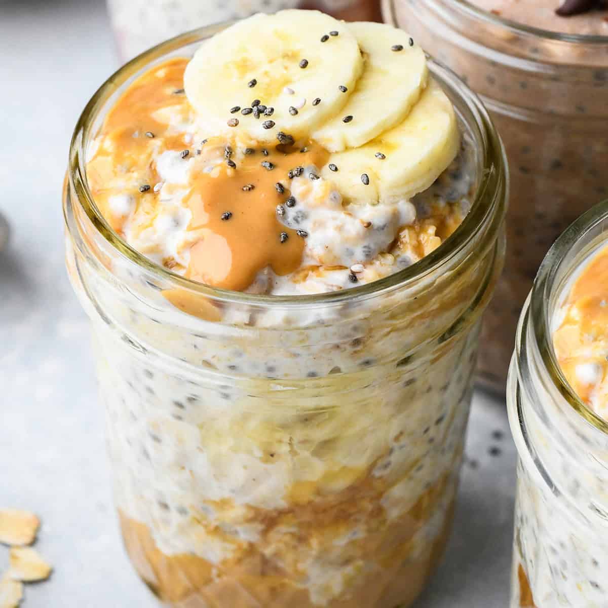 Peanut Butter Overnight Oats in a glass jar topped with bananas, chia seeds and more peanut butter