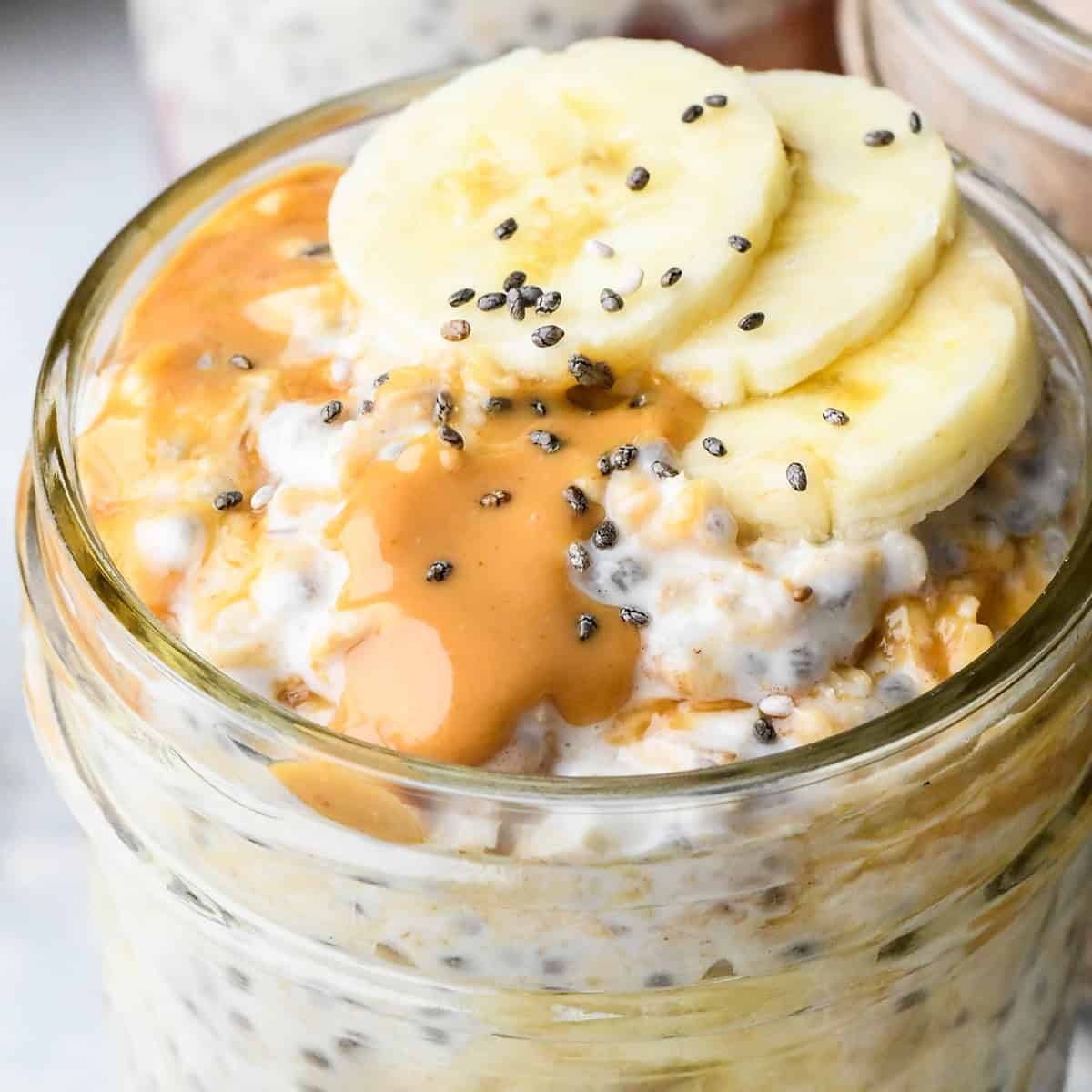 up close photo of Peanut Butter Overnight Oats in a glass jar topped with bananas and chia seeds