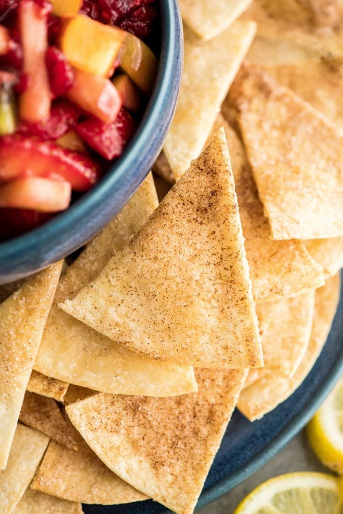 up close overhead view of a cinnamon chip next to a bowl of Fruit Salsa