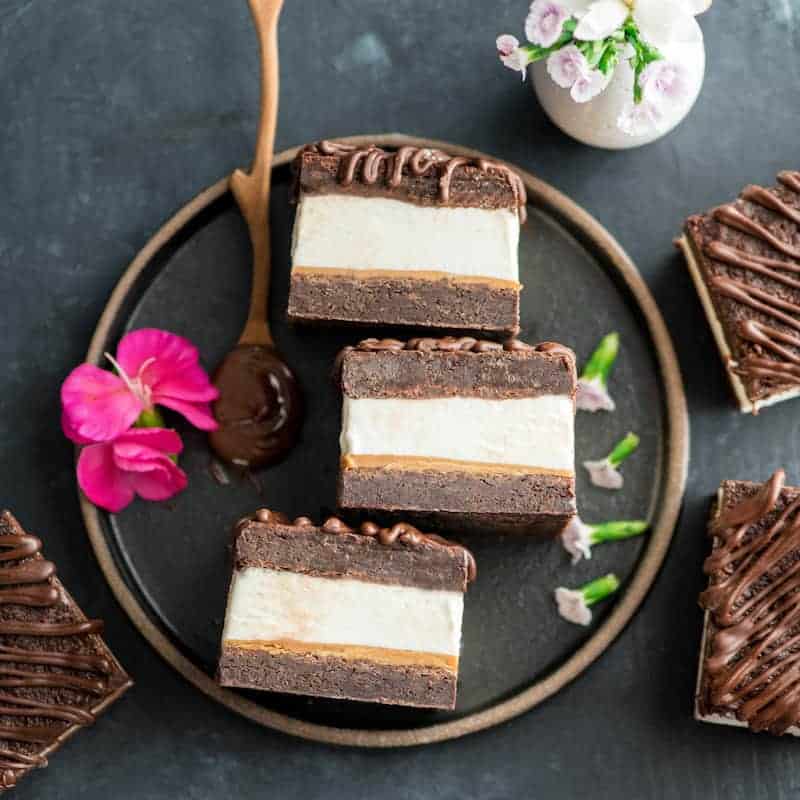 Overhead view of three Brownie Ice Cream Sandwiches on a plate with three others around them