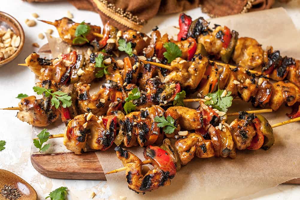 chicken satay skewers on a plate 