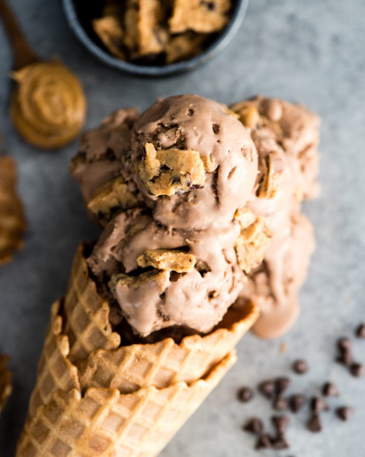 Up close overhead view of four scoops of Dairy-Free Chocolate Peanut Butter Cookie Dough Ice Cream in a waffle cone