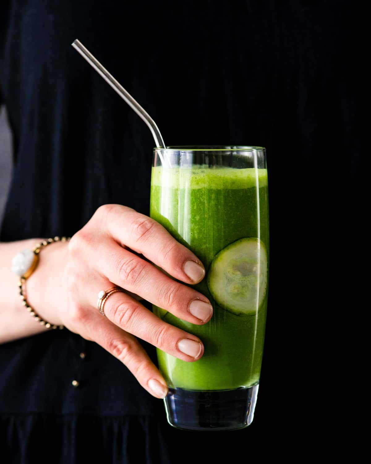 Front view of a hand holding a Zucchini Smoothie