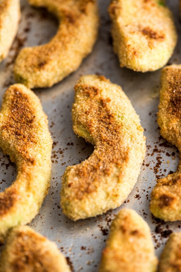 up close view of baked avocado fries on a baking sheet after baking