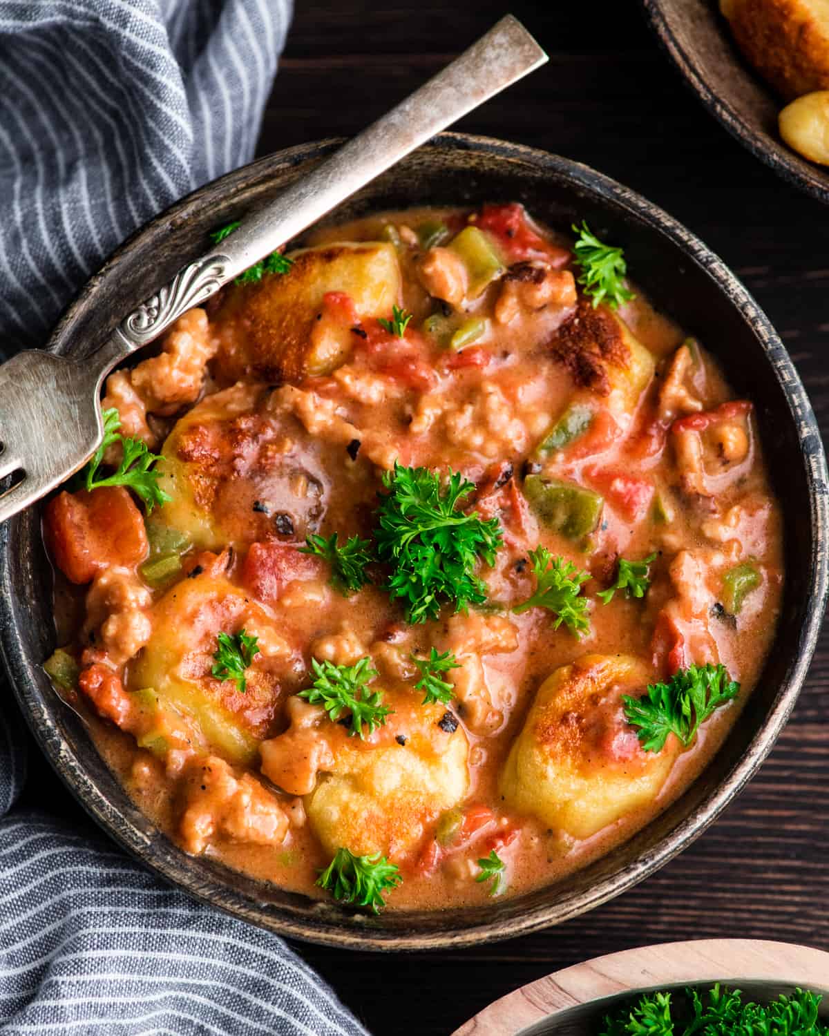 Overhead view of Cheesy Sausage Gnocchi recipe in a bowl garnished with fresh parsley