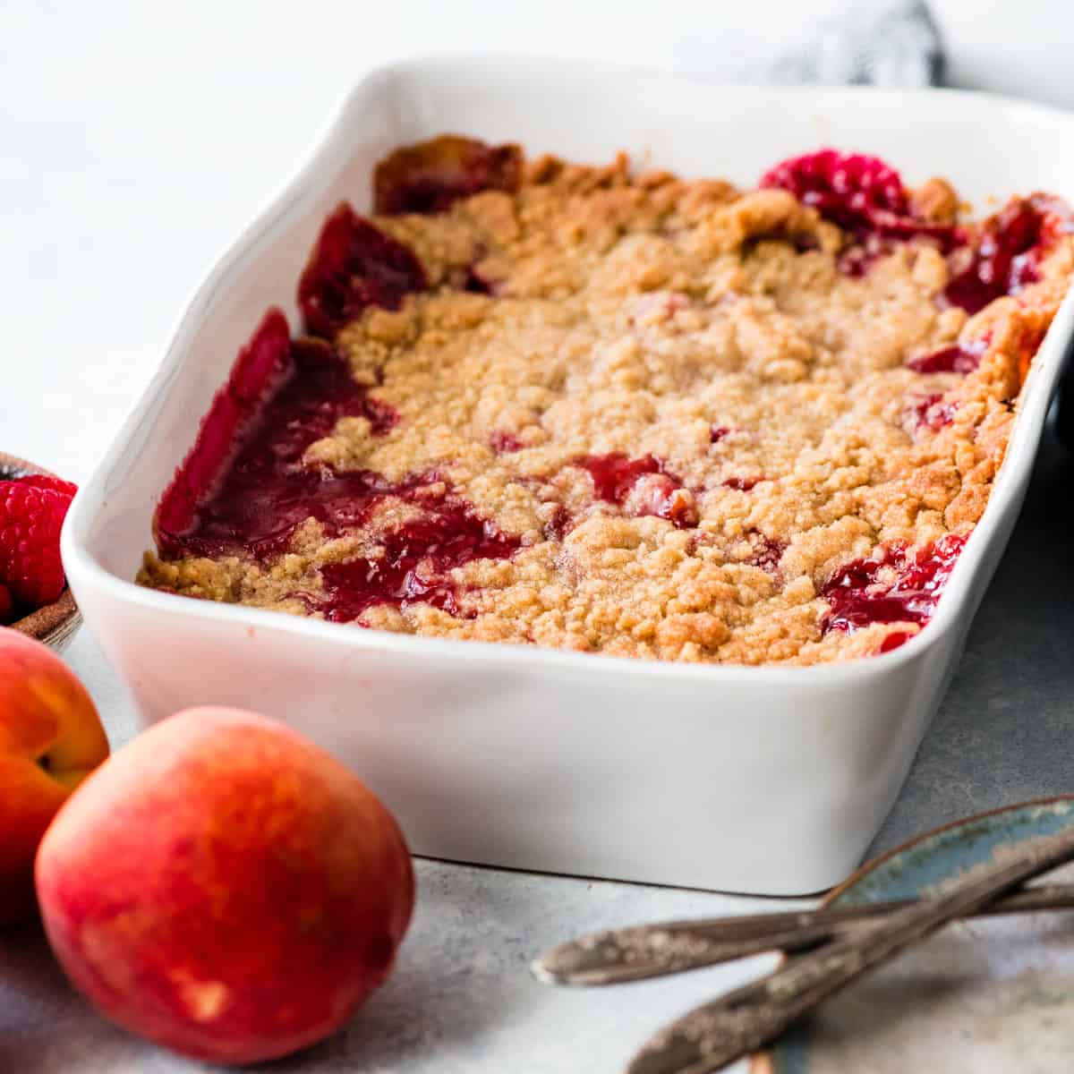 front view of Raspberry Peach Crisp in a white rectangular baking dish