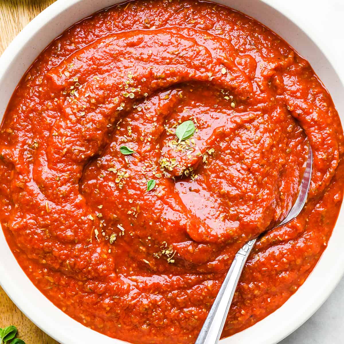 homemade pizza sauce in a bowl with a spoon