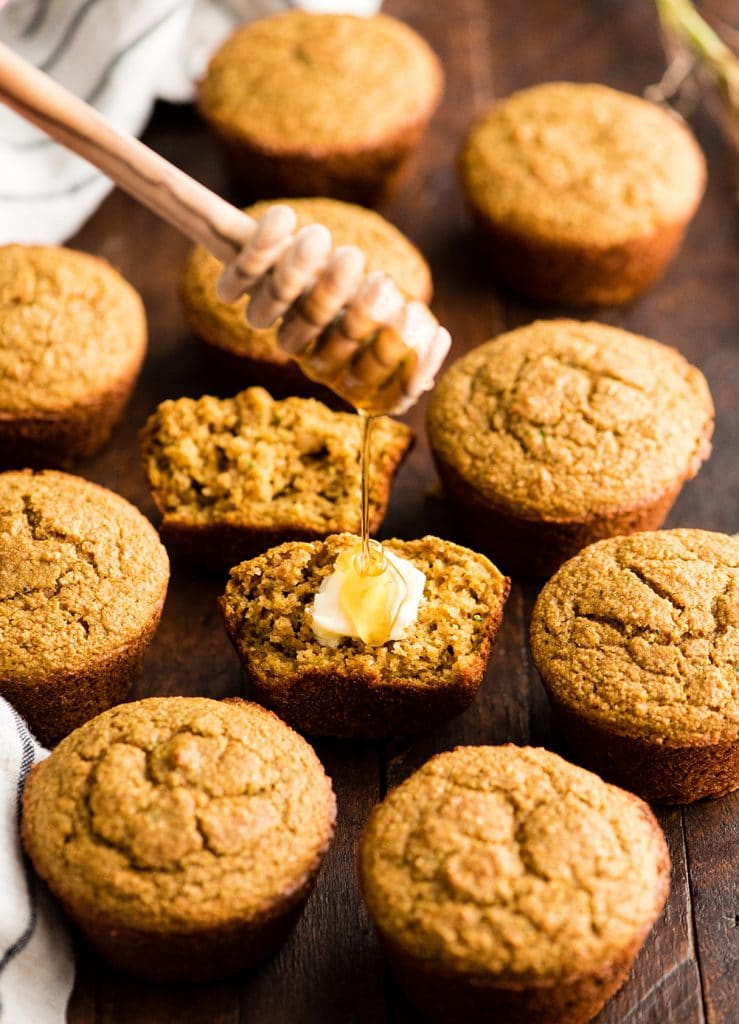 front view of honey being drizzled onto a Carrot Zucchini Muffin that's cut in half