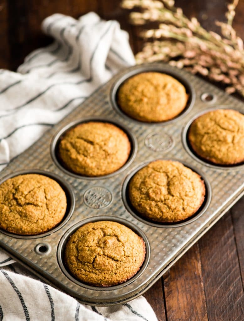 front view of a muffin tin with 6 Carrot Zucchini Muffins after they have been baked