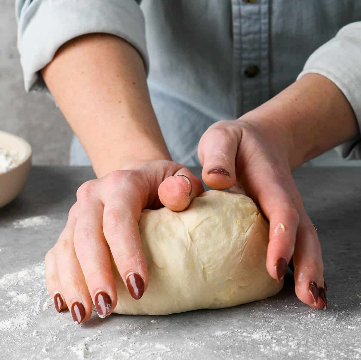 hands kneading pizza dough