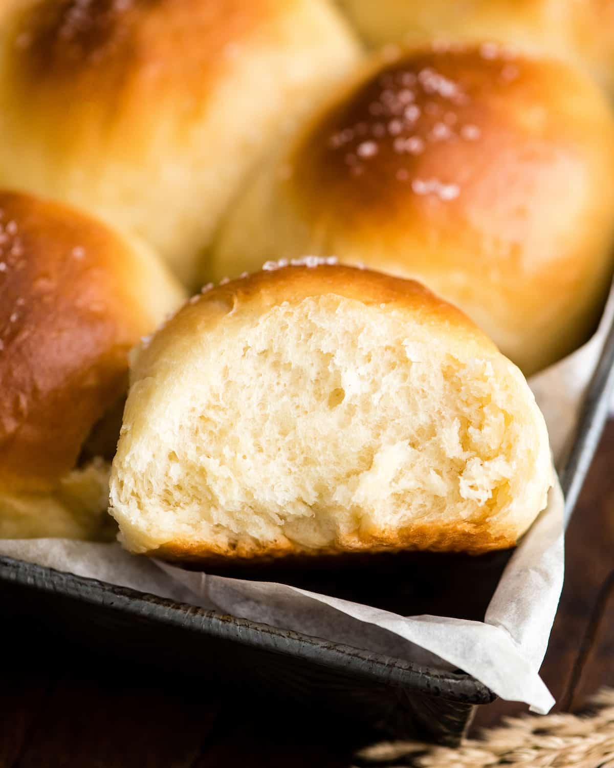 overhead/front view of a Homemade Dinner Roll cut in half with a square of butter