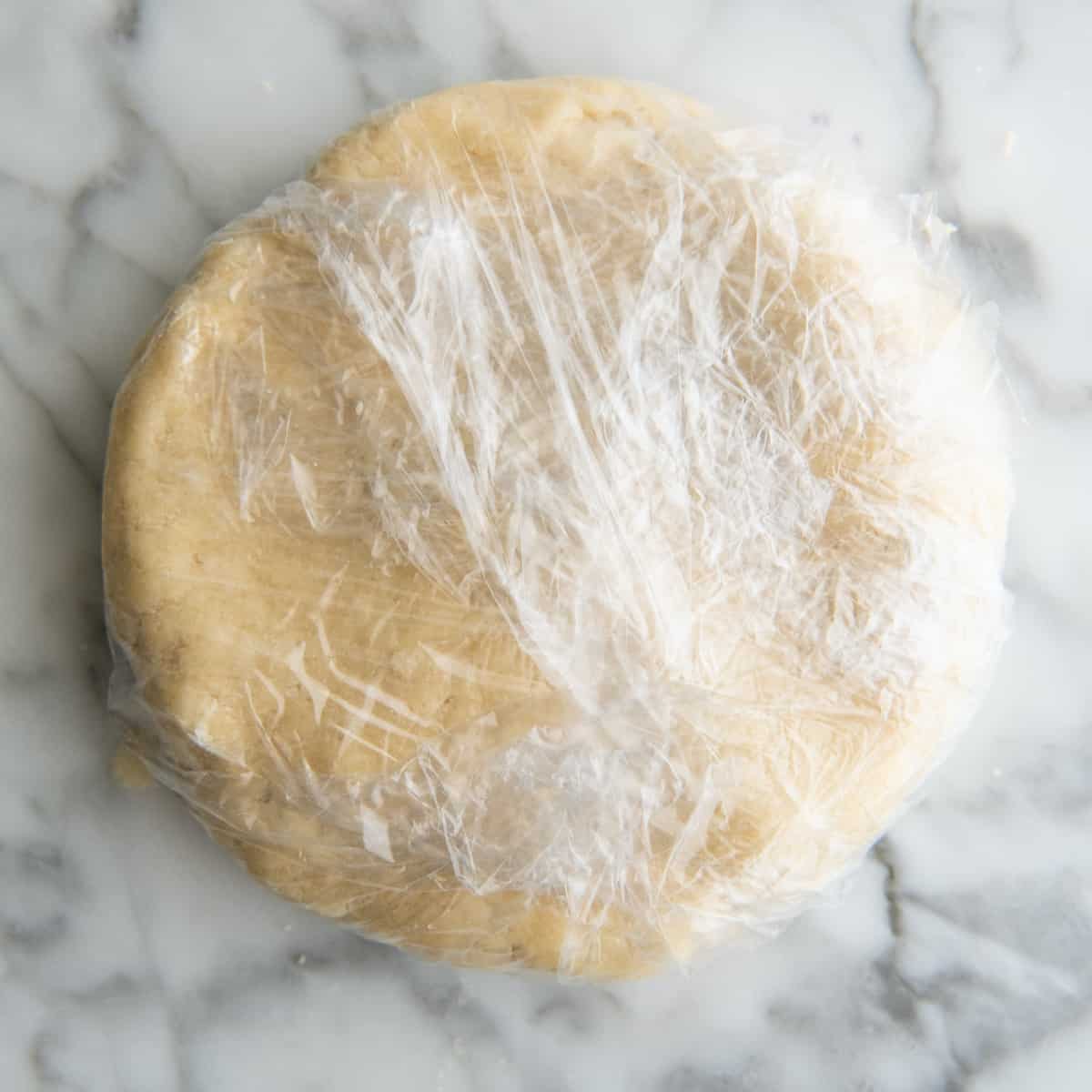 dairy free pie crust wrapped in plastic wrap to chill