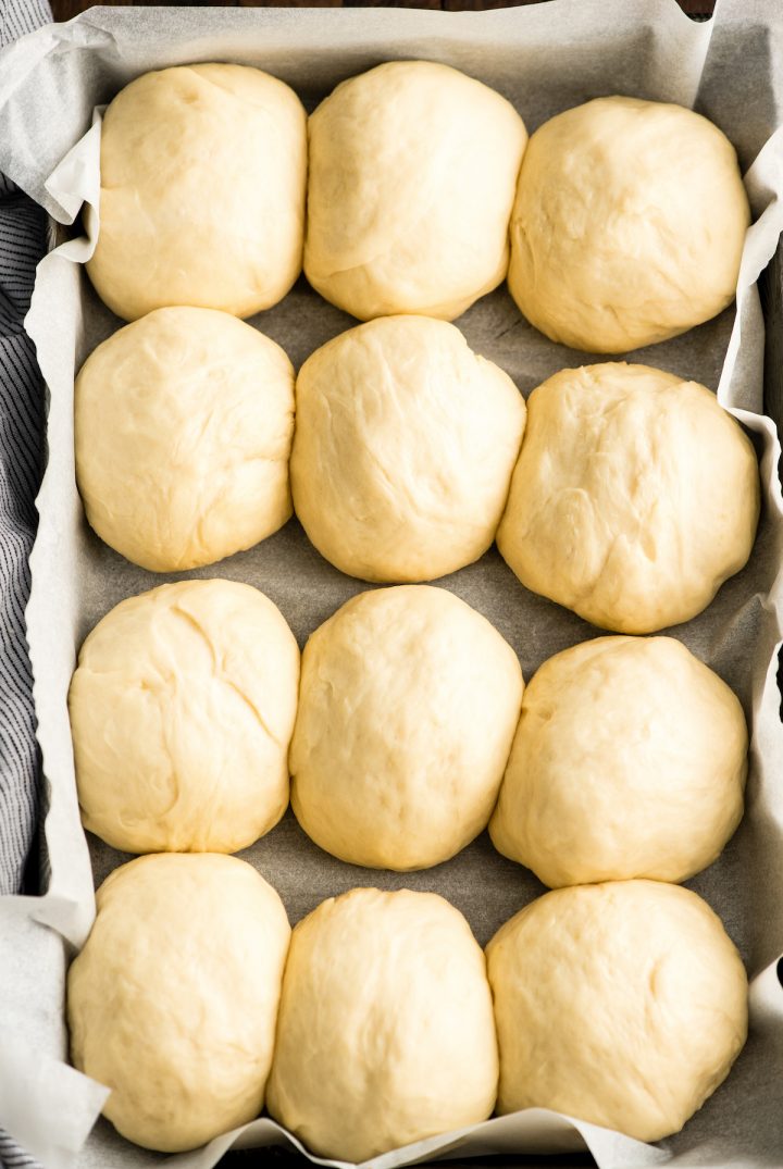 overhead view of a pan of dinner roll dough after it has risen 