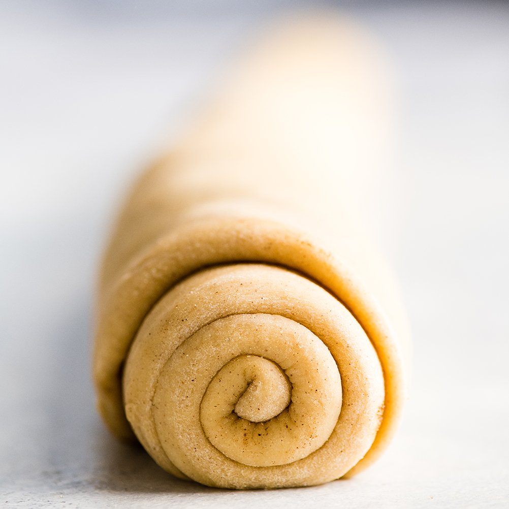 front view of the best cinnamon rolls recipe dough and filling all rolled up and ready to be cut