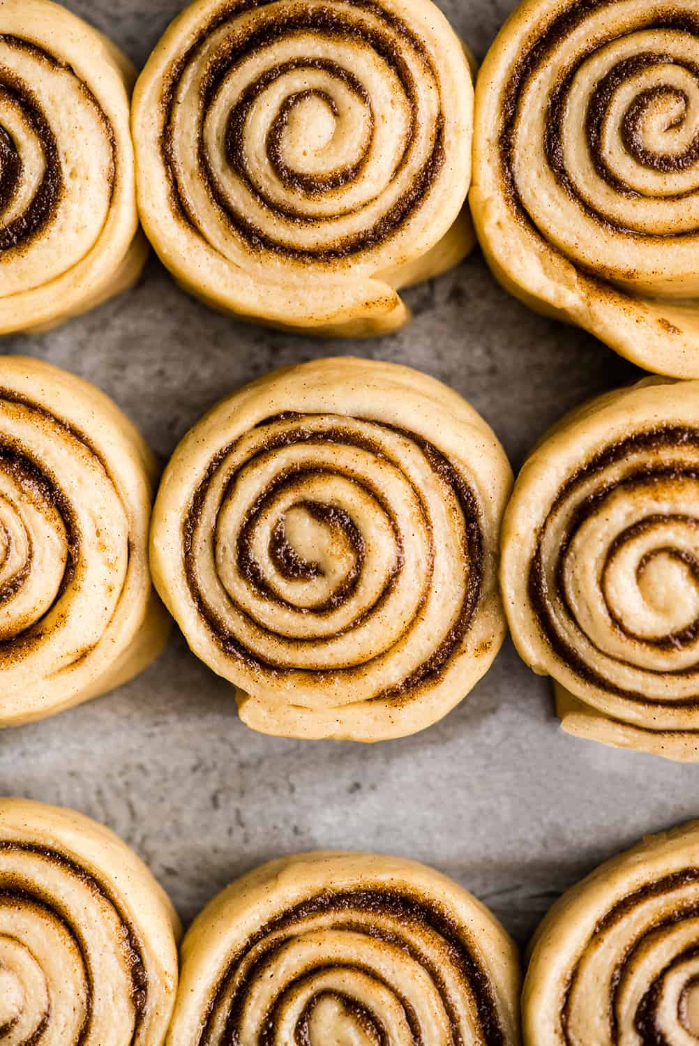 overhead photo showing how to make cinnamon rolls - rolls risen in baking pan