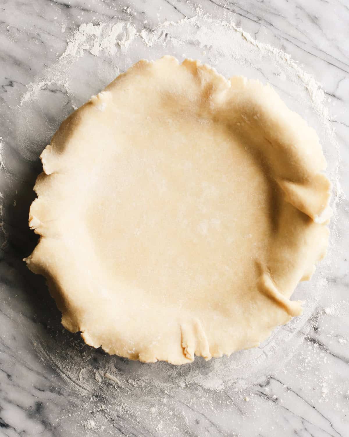 a butter pie crust in a pie plate before baking
