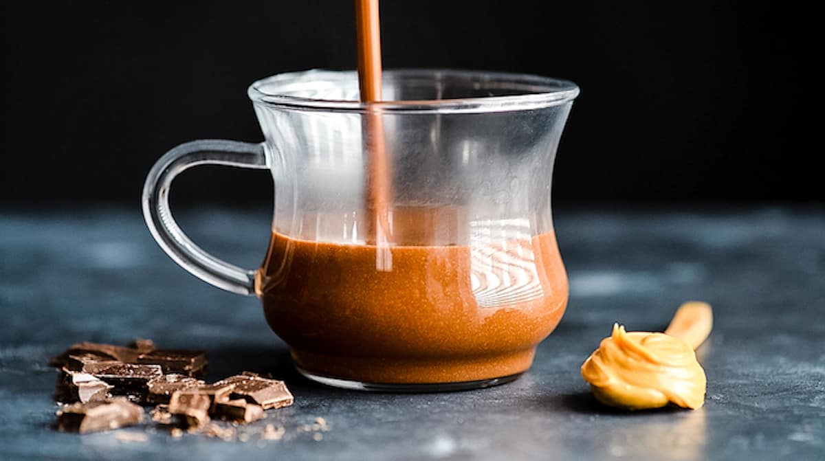 Peanut Butter Hot Chocolate being poured into a glass mug