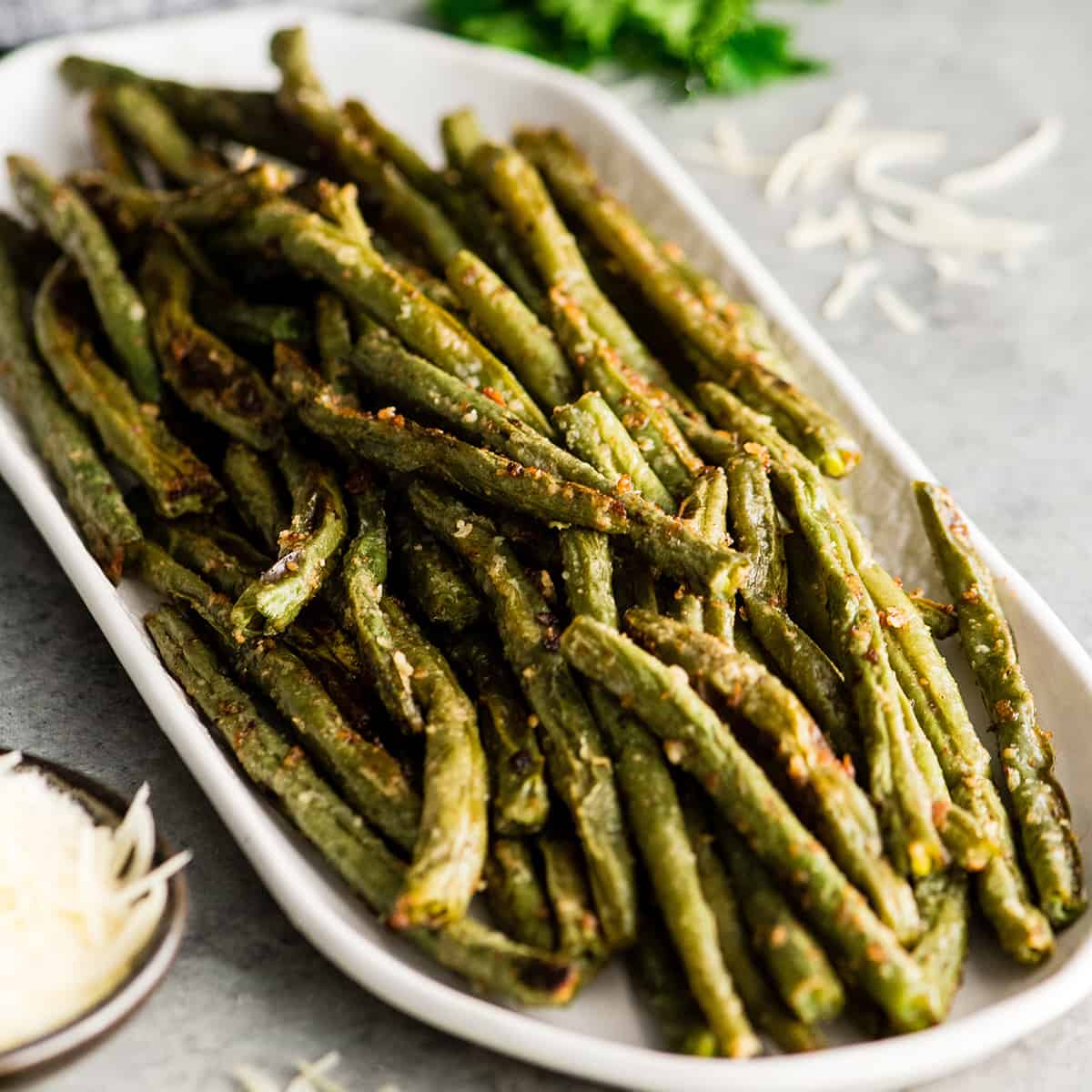 Front view of a serving dish with Roasted Parmesan Green Beans 