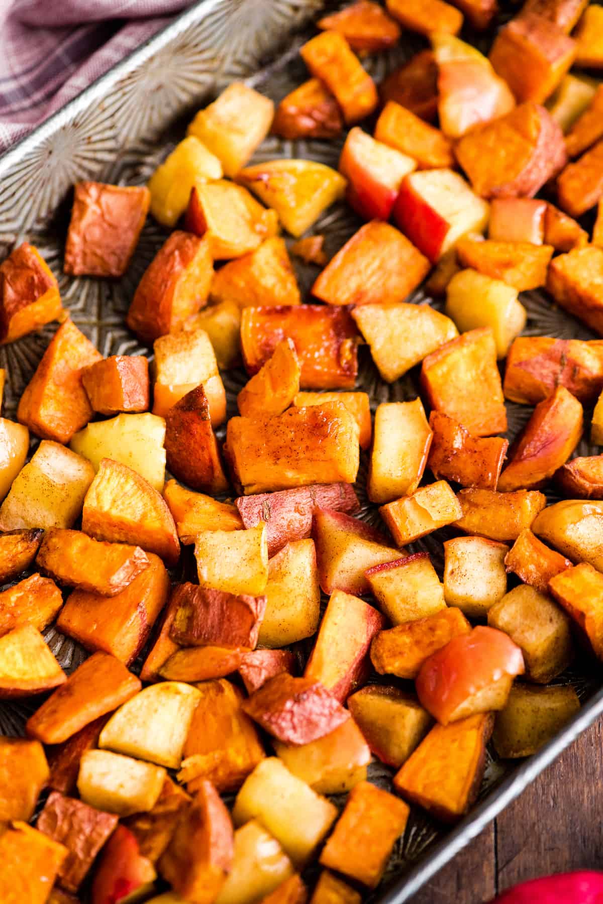 Overhead view of Cinnamon Roasted Sweet Potatoes and Apples on a baking sheet after being roasted