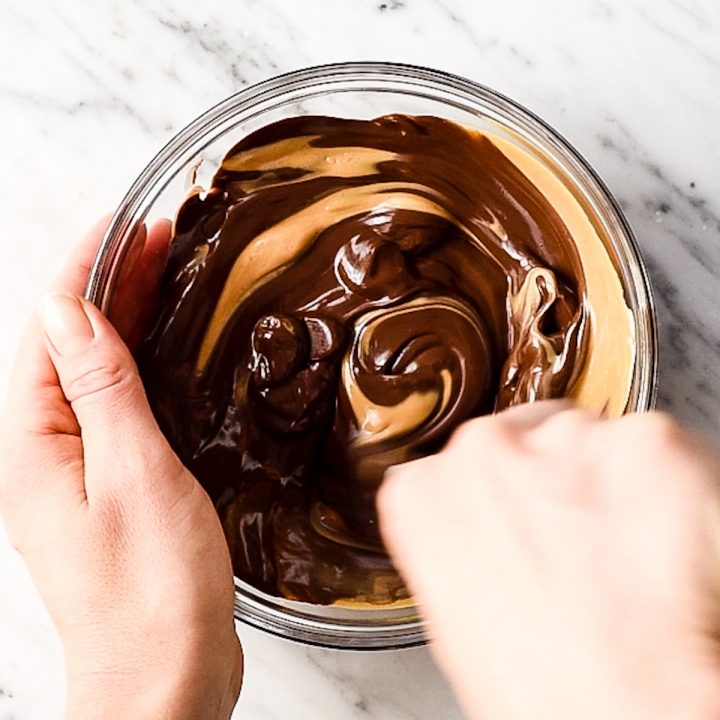 overhead view of a bowl of melted chocolate and peanut butter being mixed together to make the topping for these No-Bake Chocolate Peanut Butter Bars