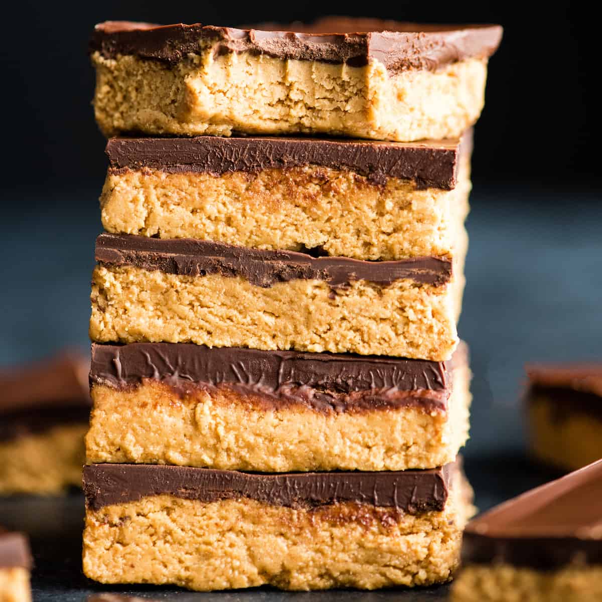 front view of a stack of five No-Bake Chocolate Peanut Butter Bars, the top one has a bite taken out of it