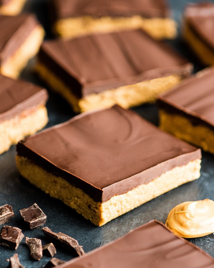 Front view of nine No-Bake Chocolate Peanut Butter Bars arranged on a surface 