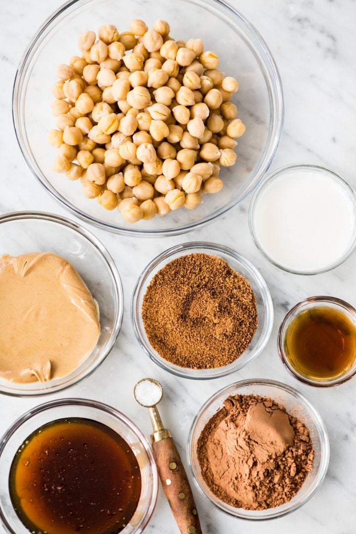 Healthy Chocolate Hummus Recipe is easy to make and ready in 5 minutes! It's a nutritious dip, appetizer, dessert, snack or spread that everyone in my family, including my kids, loves. This dessert hummus recipe is gluten-free, dairy-free, has no refined sugar & it's vegan! #hummus #chocolatehummus #vitamix #desserthummus #vegan Overhead photo of the ingredients used to make Chocolate Hummus