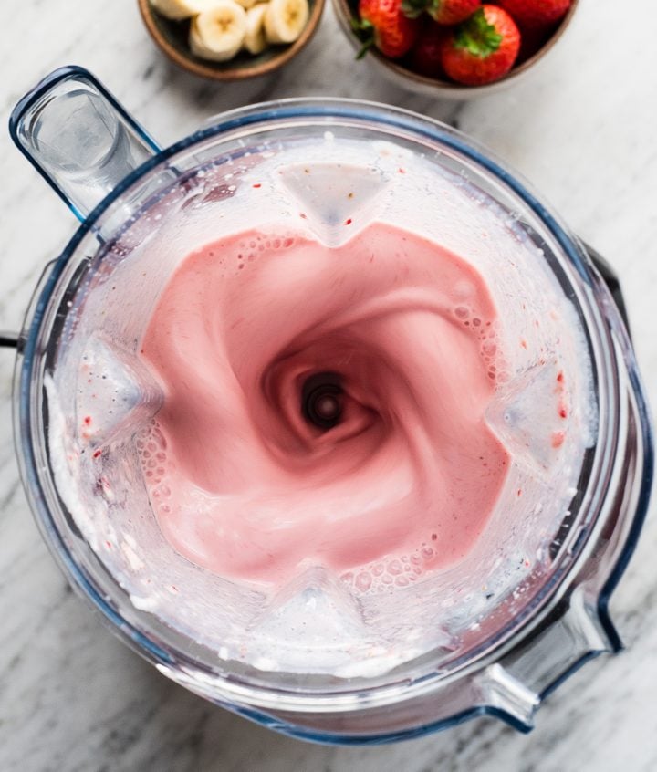 Overhead view of a Strawberry Banana Smoothie being blended in a Vitamix blender 
