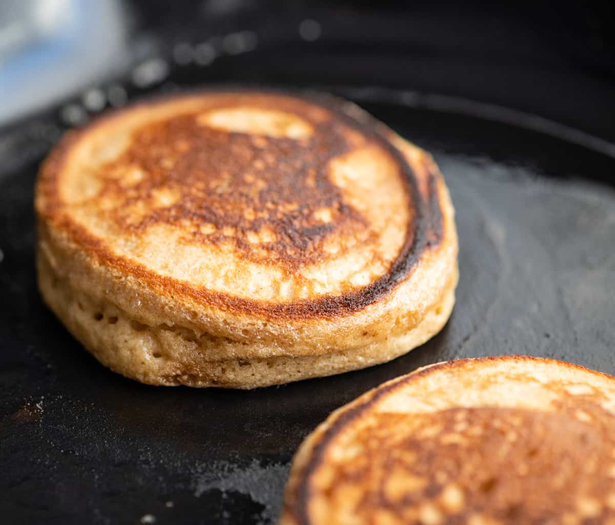 front view of a Greek Yogurt Pancake cooking in a cast iron skillet