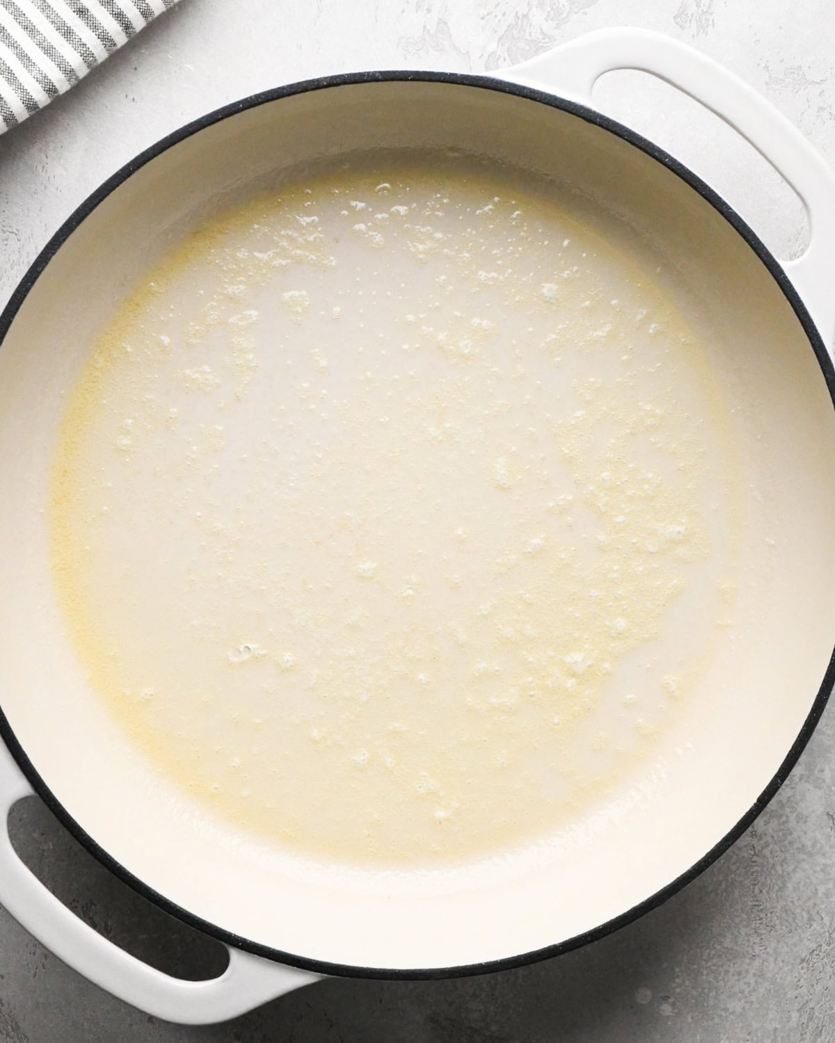 melted butter in a white skillet making greek yogurt pancakes