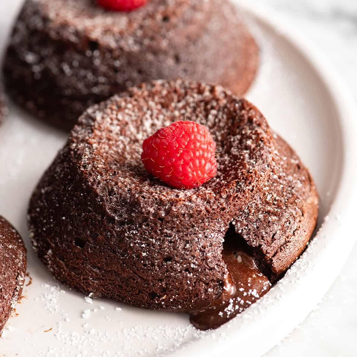 front view of a Molten Chocolate Lava Cake with a little bit of chocolate filling oozing out