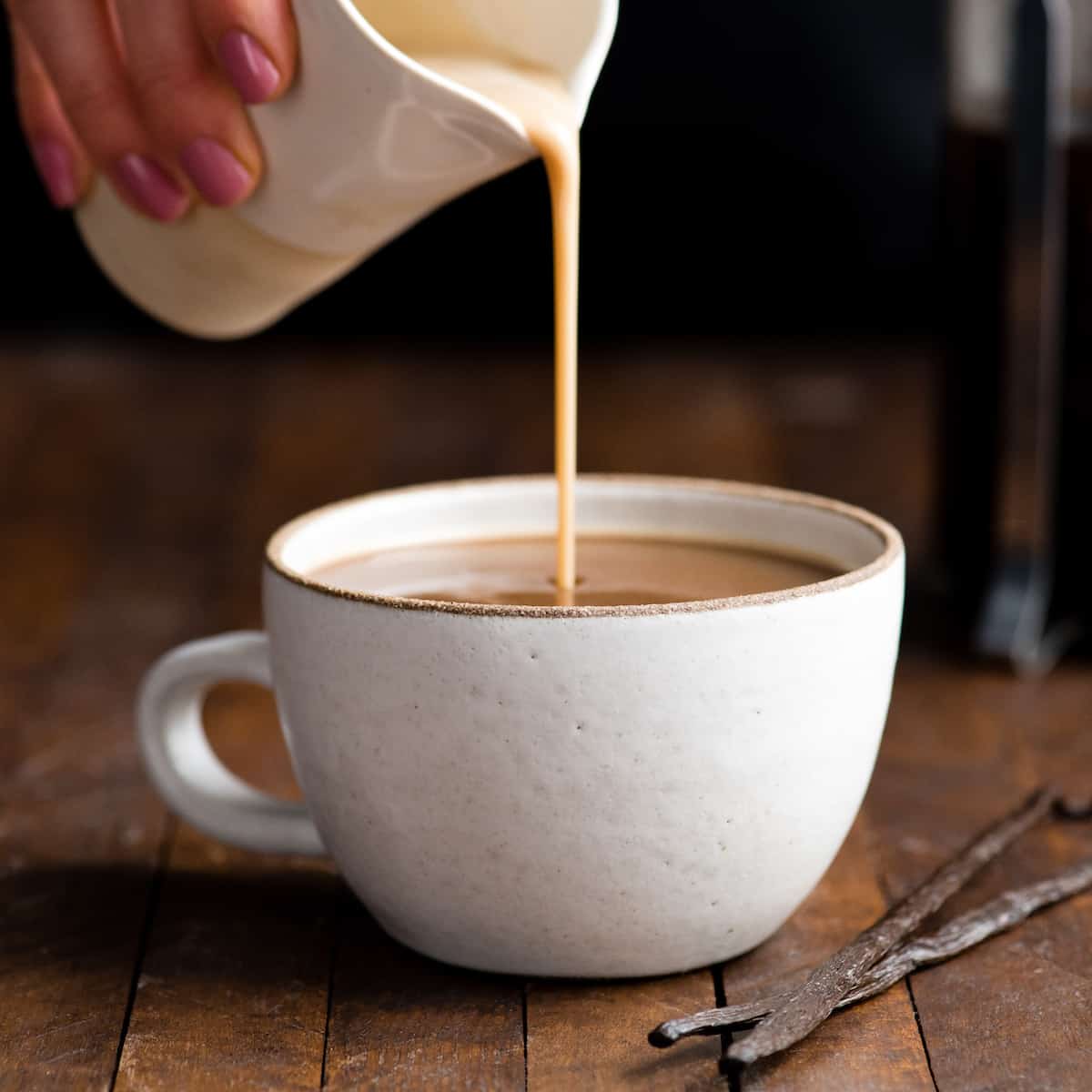 Front view of healthy coffee creamer being poured into a mug of coffee