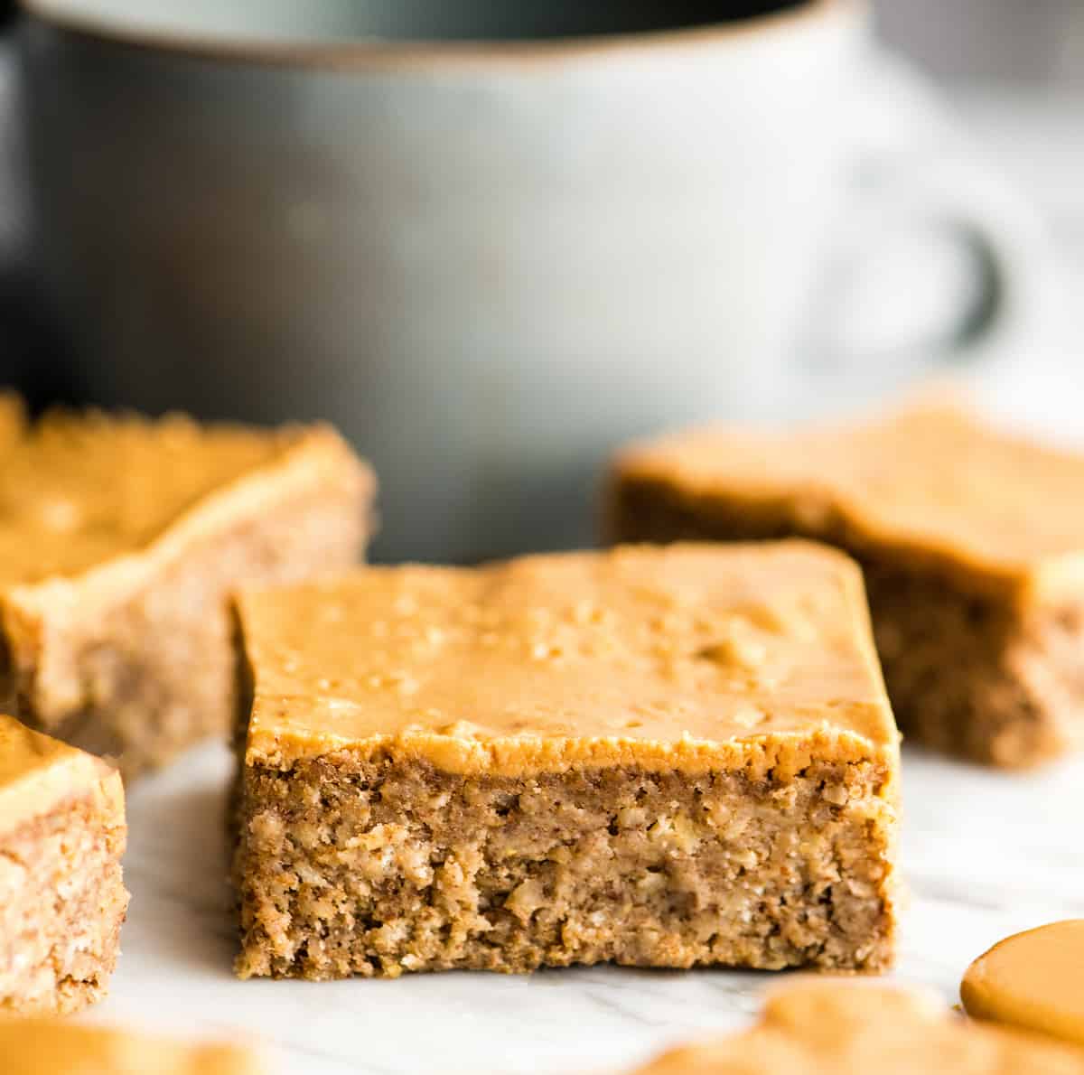 3 Healthy Peanut Butter Breakfast Bars with a cup of coffee in the background 