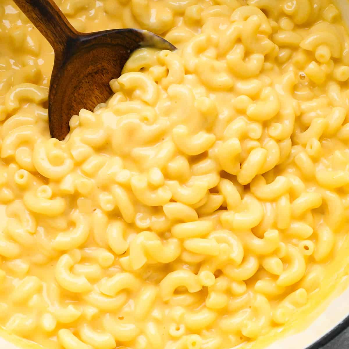 overhead photo of homemade mac and cheese in a pot with a spoon taking a scoop