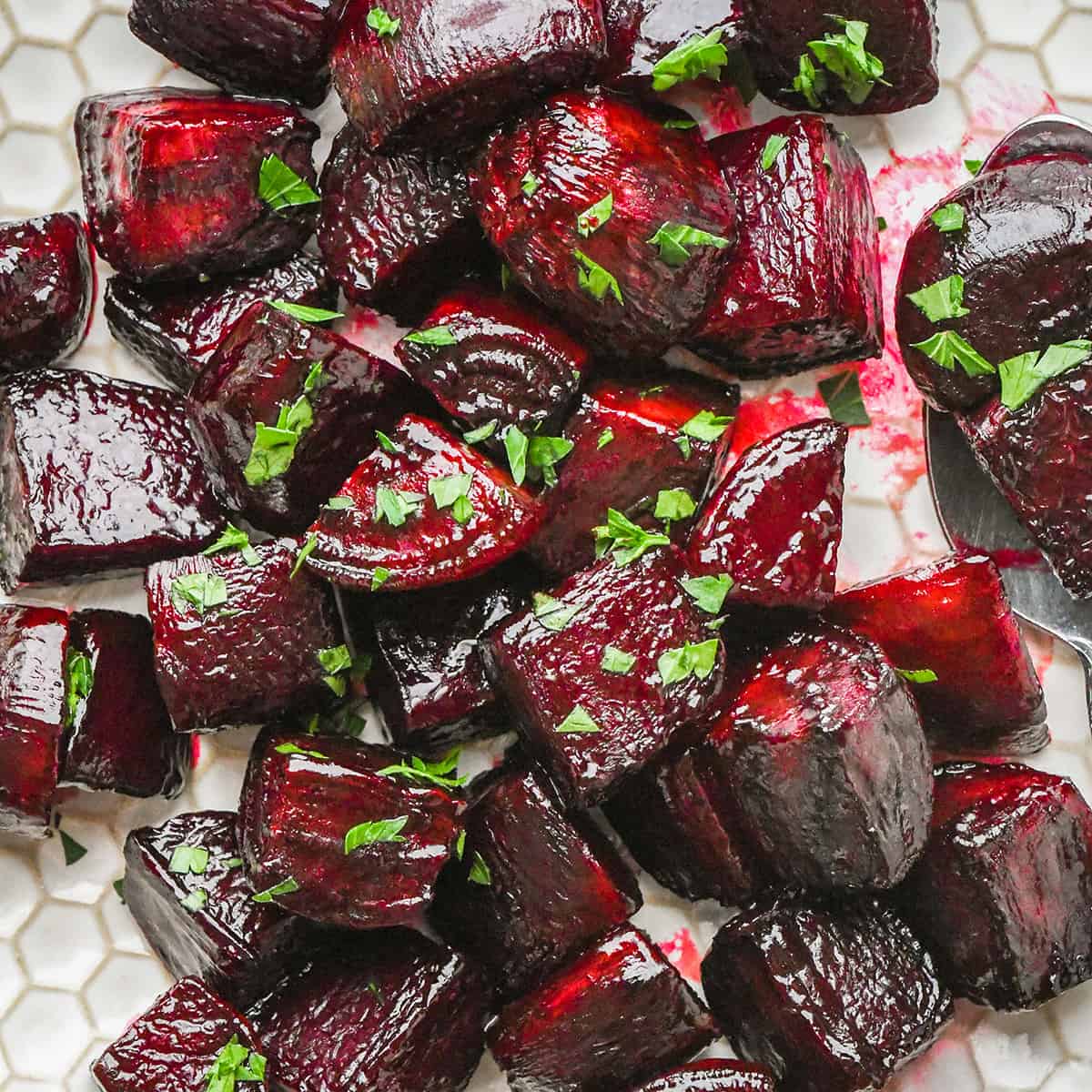 oven roasted beets on a plate garnished with beet greens