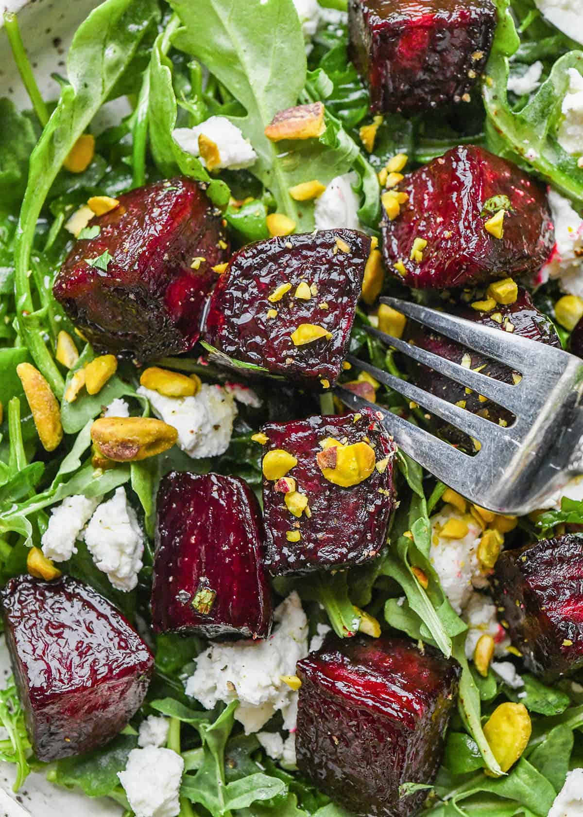 roasted beets on a salad with a fork