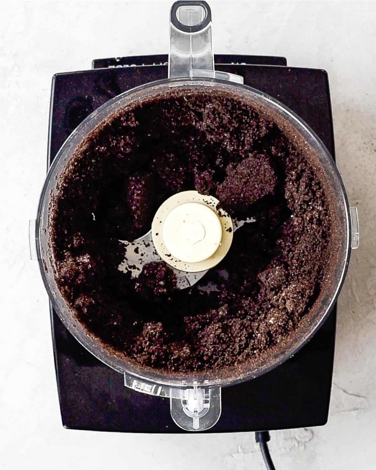 making oreo dirt cake recipe - oreo crumbs in a food processor fitted with the "S" attachment