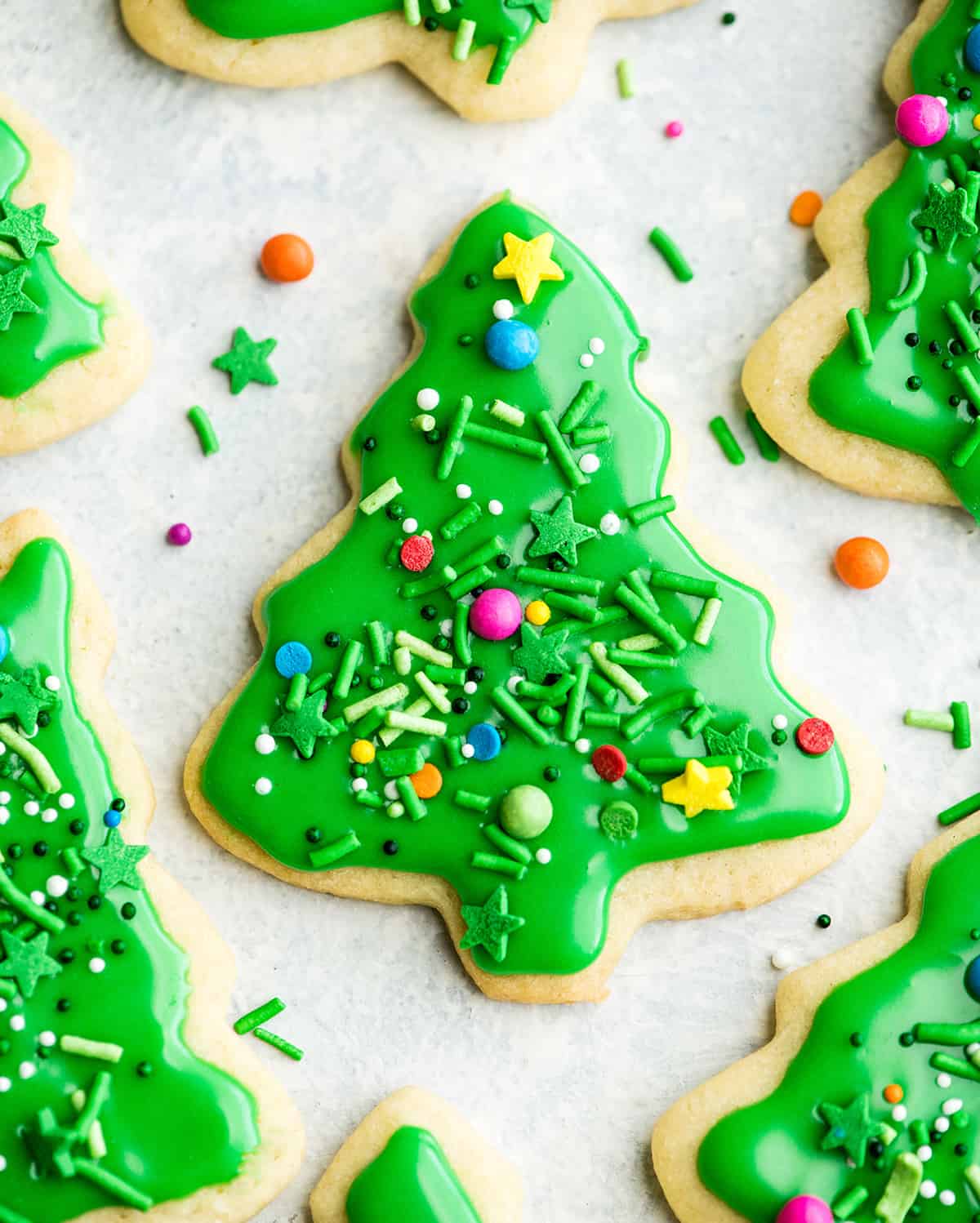 overhead view of a green Christmas tree sugar cookie with sprinkles